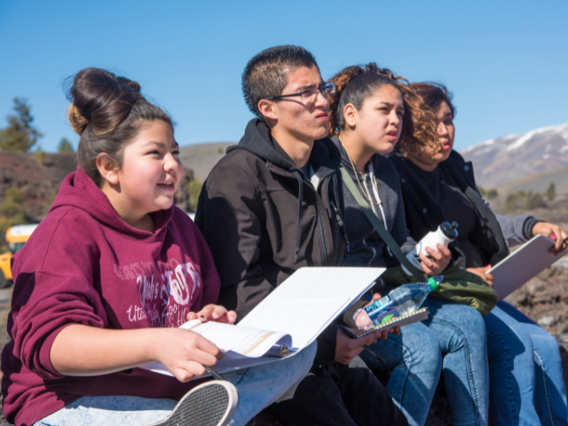 Photo of students learning outside with mountains in the background