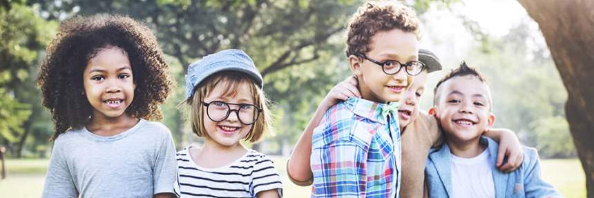 a diverse group of young kids together in a park