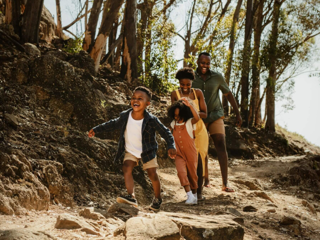 parents with two children hiking on a trail in the woods