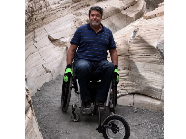Dr. Ed Price, a man in a wheelchair inside of a canyon near Las Vegas