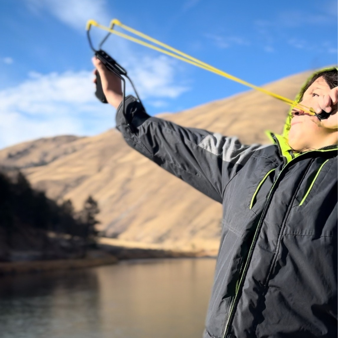 Young person with sling shot aiming a seedball