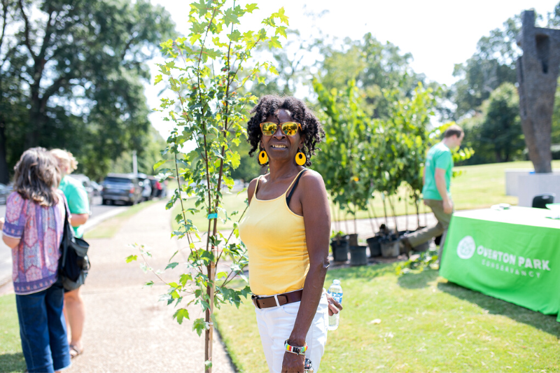 Woman hold small tree from International Paper tree give away at Overton Park