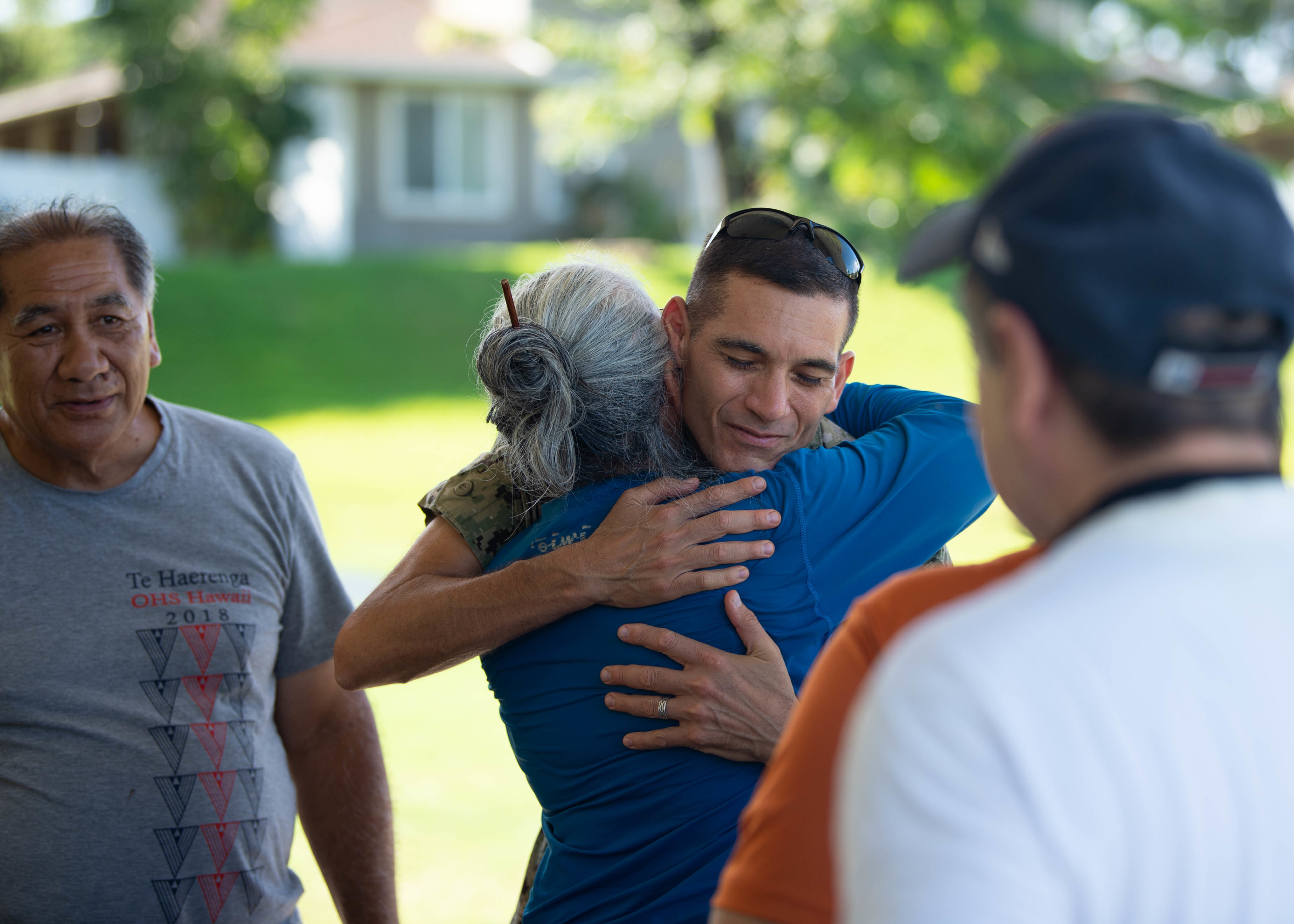 A member of the Navy hugs a local Native Hawaiian elder during a ceremony at the fishpond.