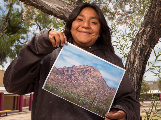 A student holds up a photo she took during a Greening STEM project at Saguaro National Park in Arizona.