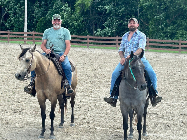 Two men on horseback smiling