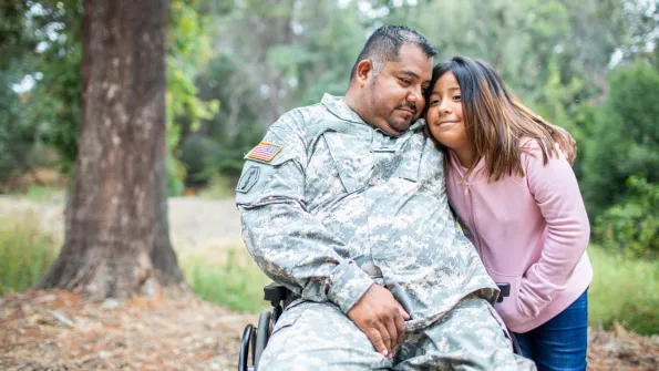 a veteran embraces his daughter in the forest