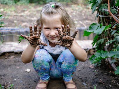 Girl in a garden in the mud