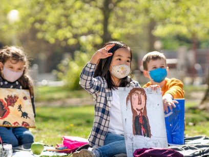 young students wearing masks in a park for an outdoor school lesson