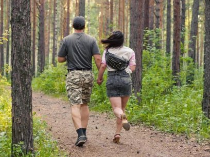 Photo of military veteran walking with a woman in a forest.