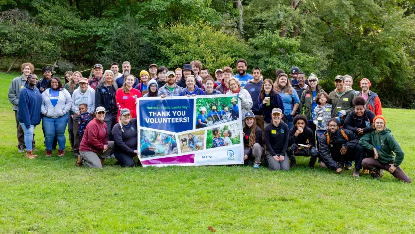 group of volunteers on National Public Lands Day stand for a group photo outside