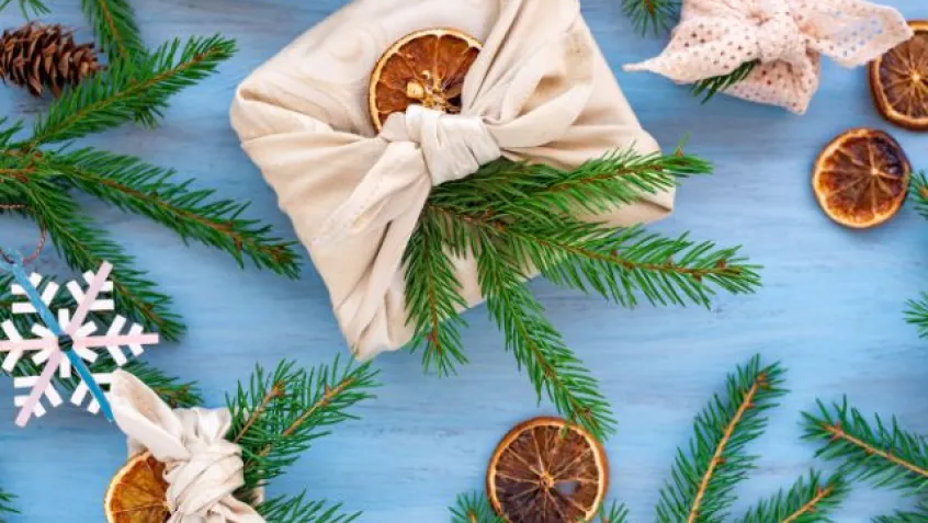Zero waste gifting wrapping using cloth wrap, dried oranges and pine tree sprigs
