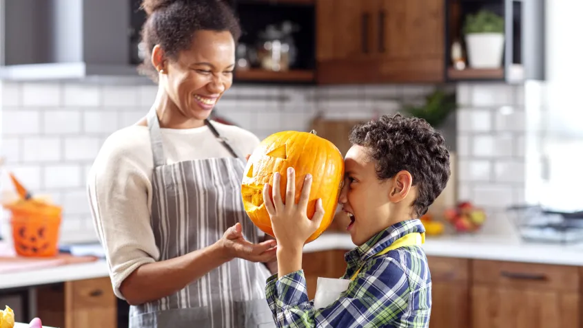 Mom and kids playing and carving pumpkins