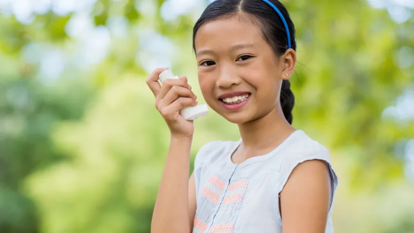 Girl smiling and using inhaler