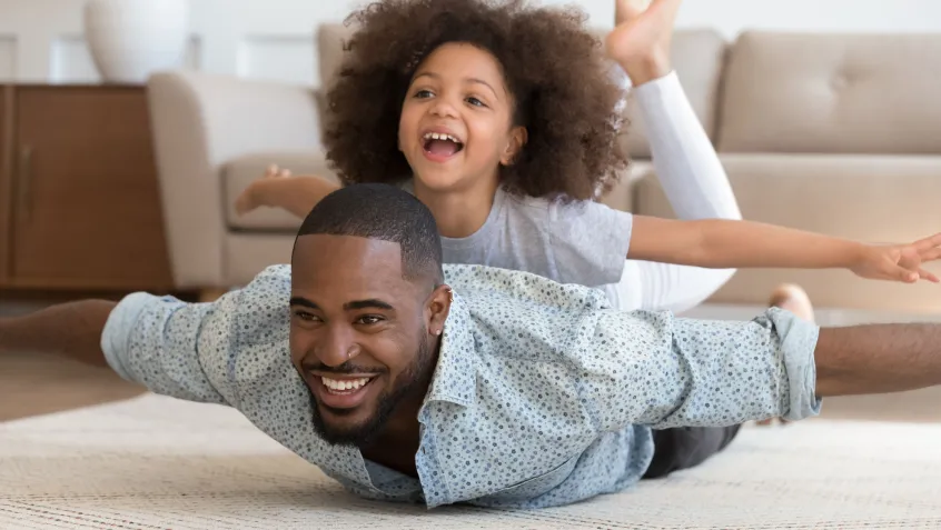 Father and daughter playing indoors