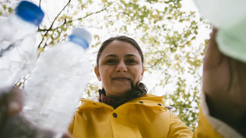 Woman putting plastic recycling into bin