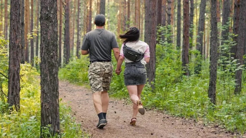 Photo of military veteran walking with a woman in a forest.