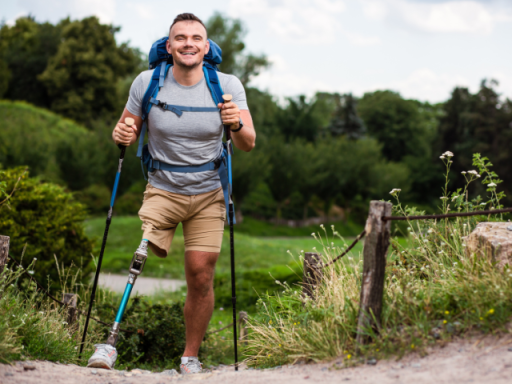 Overjoyed young man with prosthesis trying Nordic walking