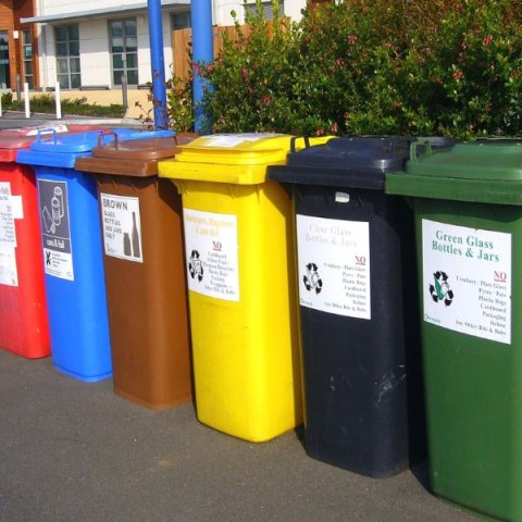 different colored waste bins stand in a row