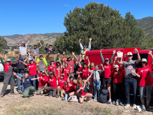 People in a group smiling, with their arms in the air after an NPLD clean up