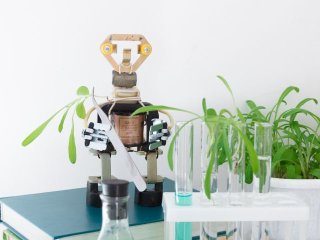 a robot stands next to test tubes filled with plants