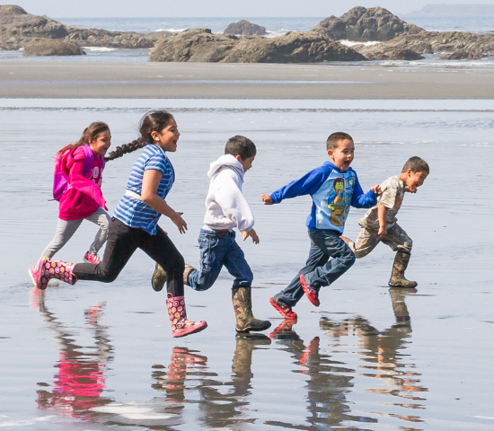 Happy kids running along the beach 