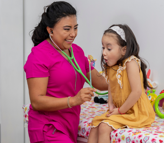 Pediatrician with young patient blowing a pinwheel