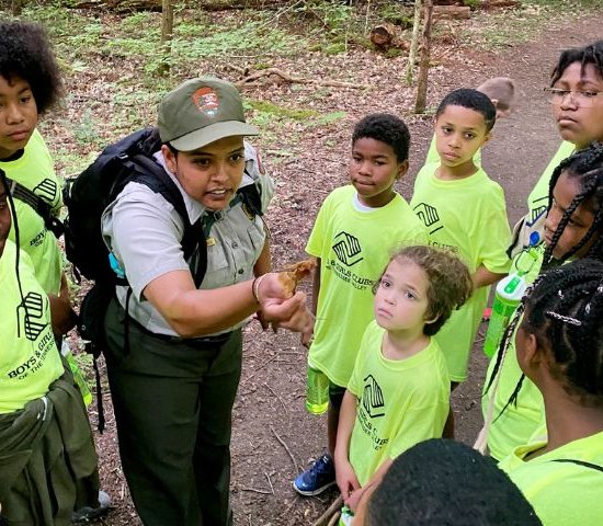 a national park ranger explains an insect to a group of students during a Greening STEM project