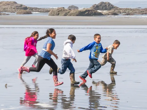Happy kids running along the beach 