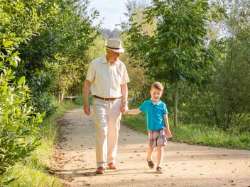 Grandfather and grandson walking in a park